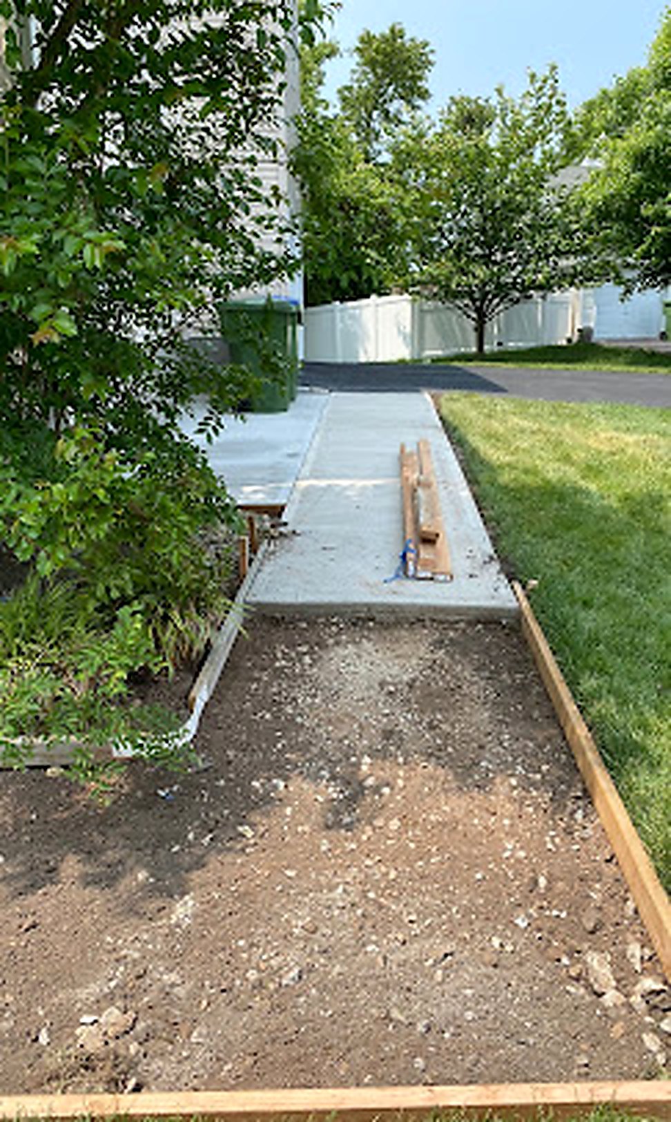 Freshly poured concrete sidewalk being finished in Central NJ